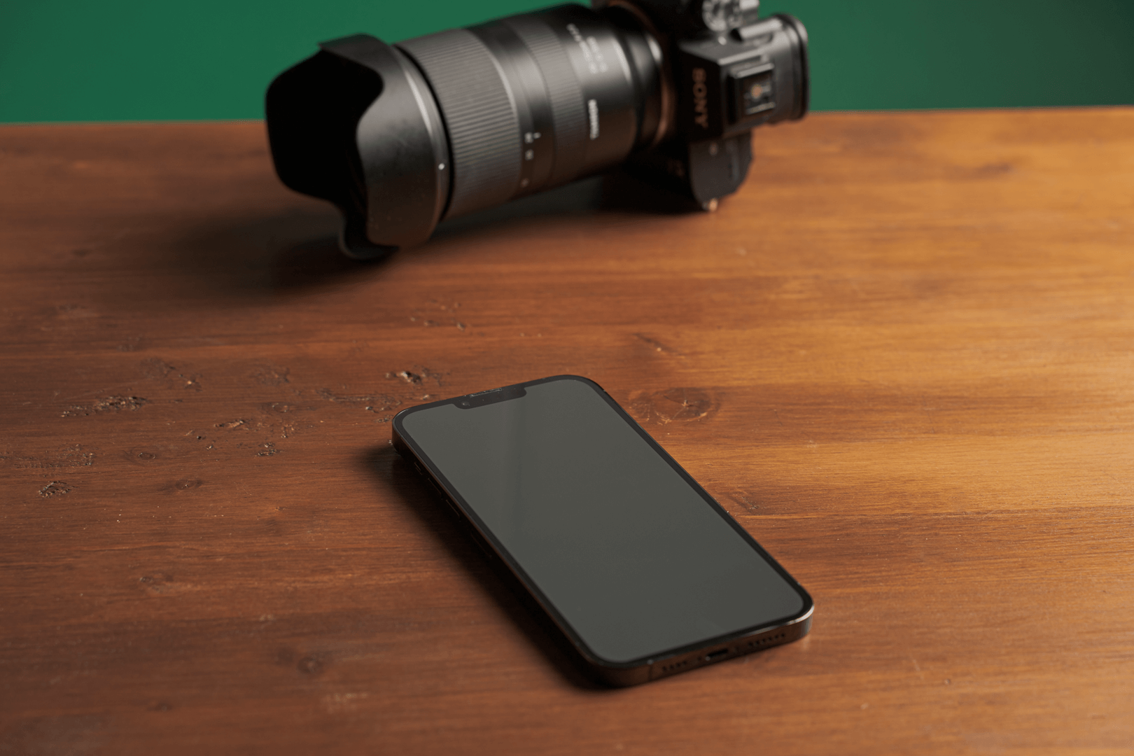Cámara y teléfono móvil sobre una mesa de madera para crear contenido para redes sociales
