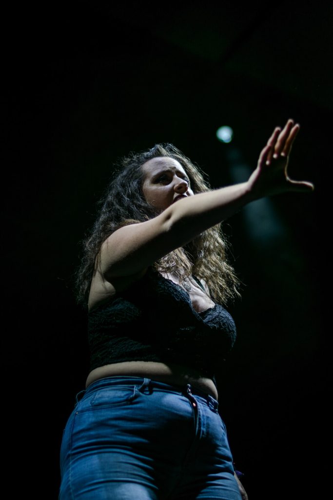 Cantante en pleno concierto fotografiada en contrapicado sobre fondo negro