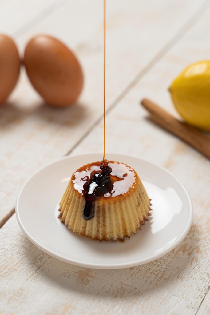 Caramelo cayendo sobre un flan en un plato blanco