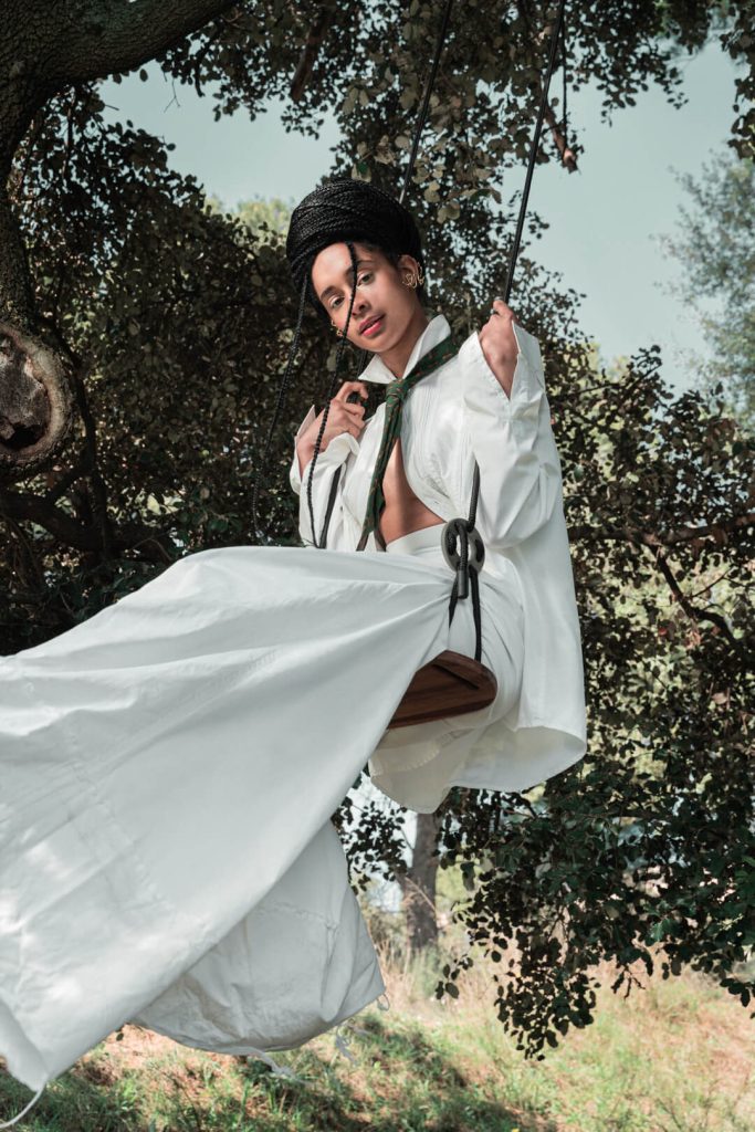 Fotografía de moda: modelo con vestido blanco posando junto a un árbol