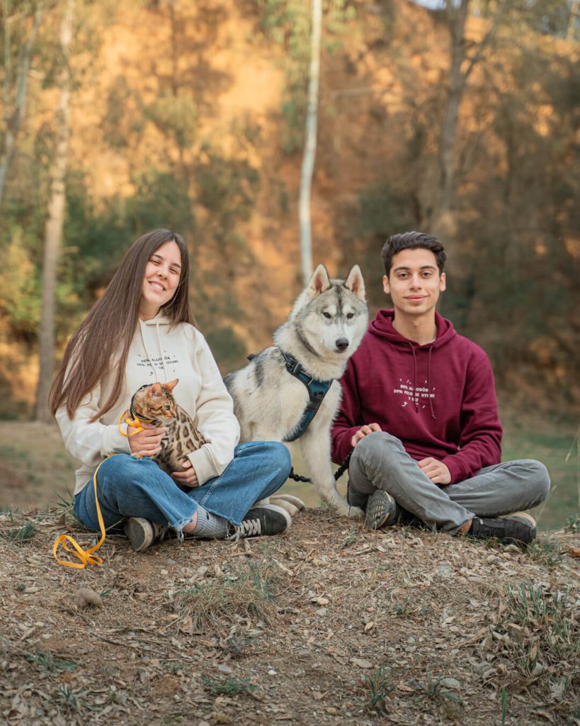 Fran y Ainoa sentados en el bosque junto a su perro Sky en una sesión de fotos de mascotas